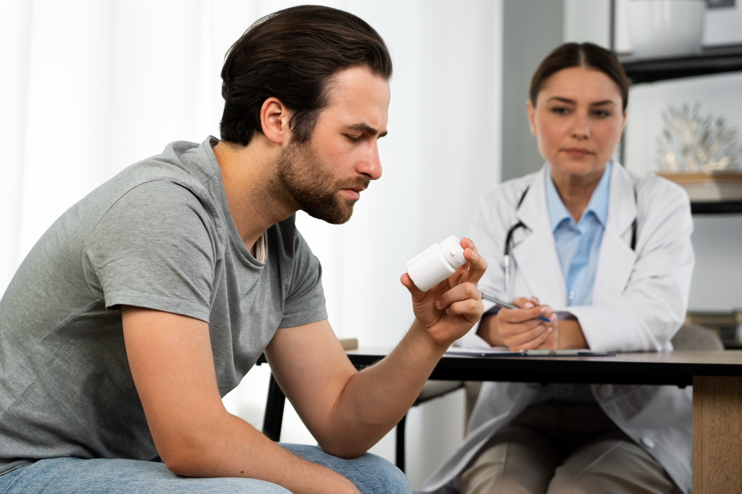 Man reviewing medication bottle during drug testing consultation in Colorado