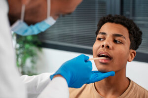 Healthcare professional administering a saliva drug test to a young man during workplace screening.