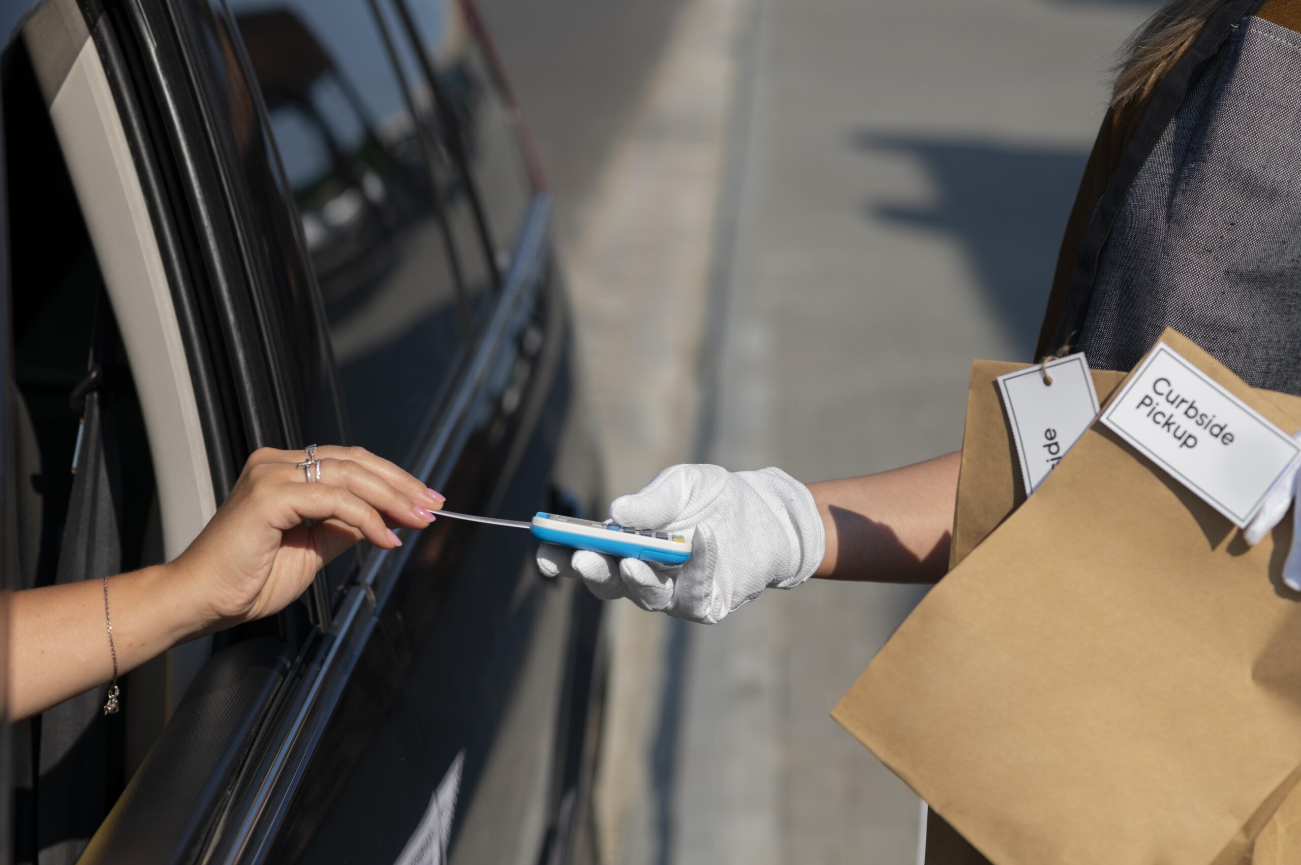 Colorado mobile drug testing curbside service with customer making contactless payment to gloved technician.