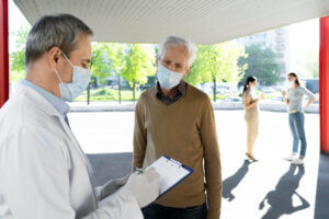 Medical professional reviewing paperwork with a patient at an outdoor testing site.
