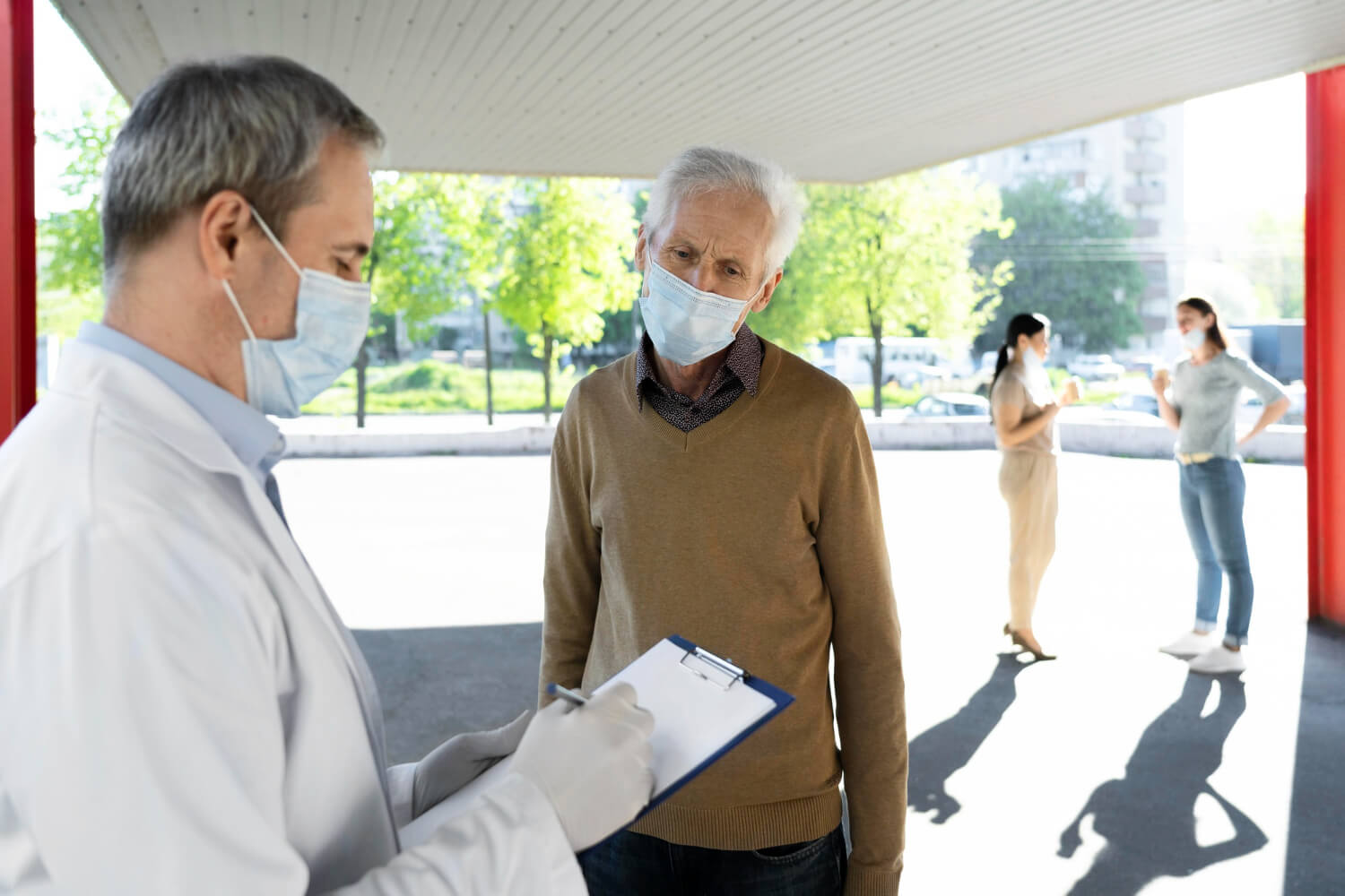 Medical professional reviewing paperwork with a patient at an outdoor testing site.