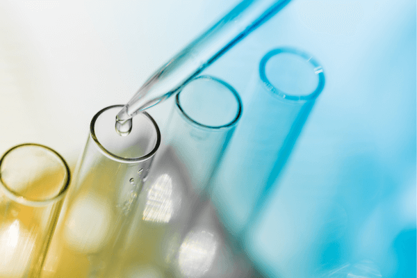 Close-up of laboratory test tubes and a pipette representing random drug testing procedures for workplace compliance and safety programs