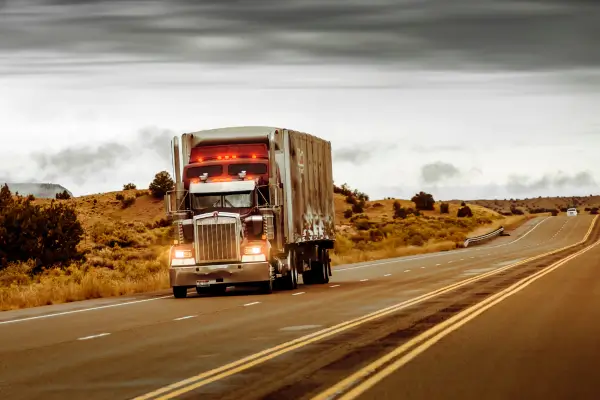 Commercial semi-truck traveling on a highway under an overcast sky, representing an FMCSA-regulated motor carrier subject to DOT drug and alcohol testing program requirements and compliance audits under 49 CFR Part 382.
